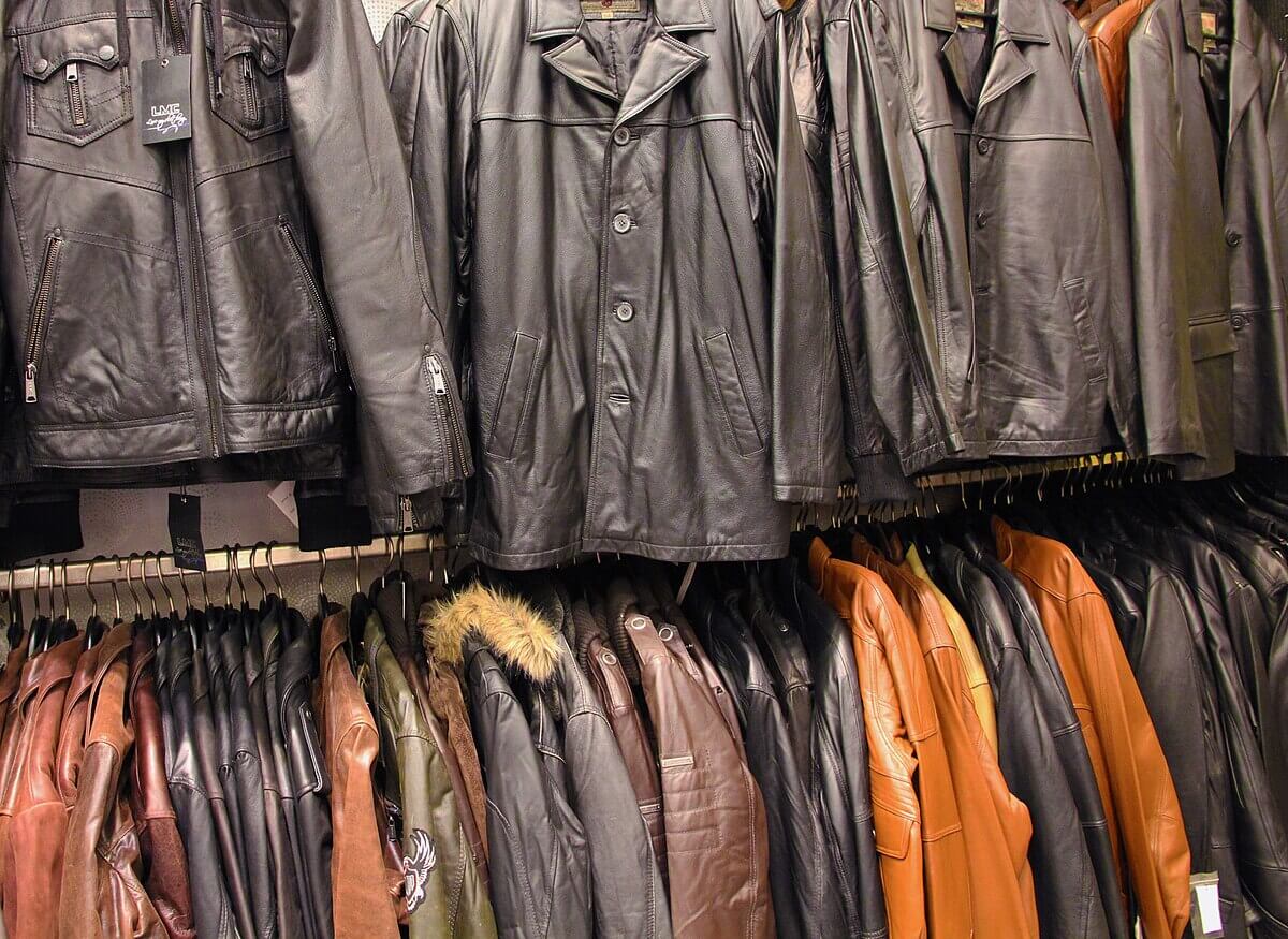 Selection of leather jackets in various styles and colors hanging on display in a store