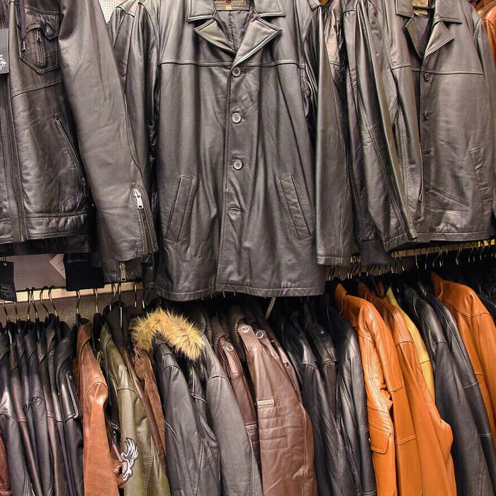 Selection of leather jackets in various styles and colors hanging on display in a store