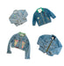 Four unique vintage denim jackets with colorful designs and patches arranged in a flat lay.